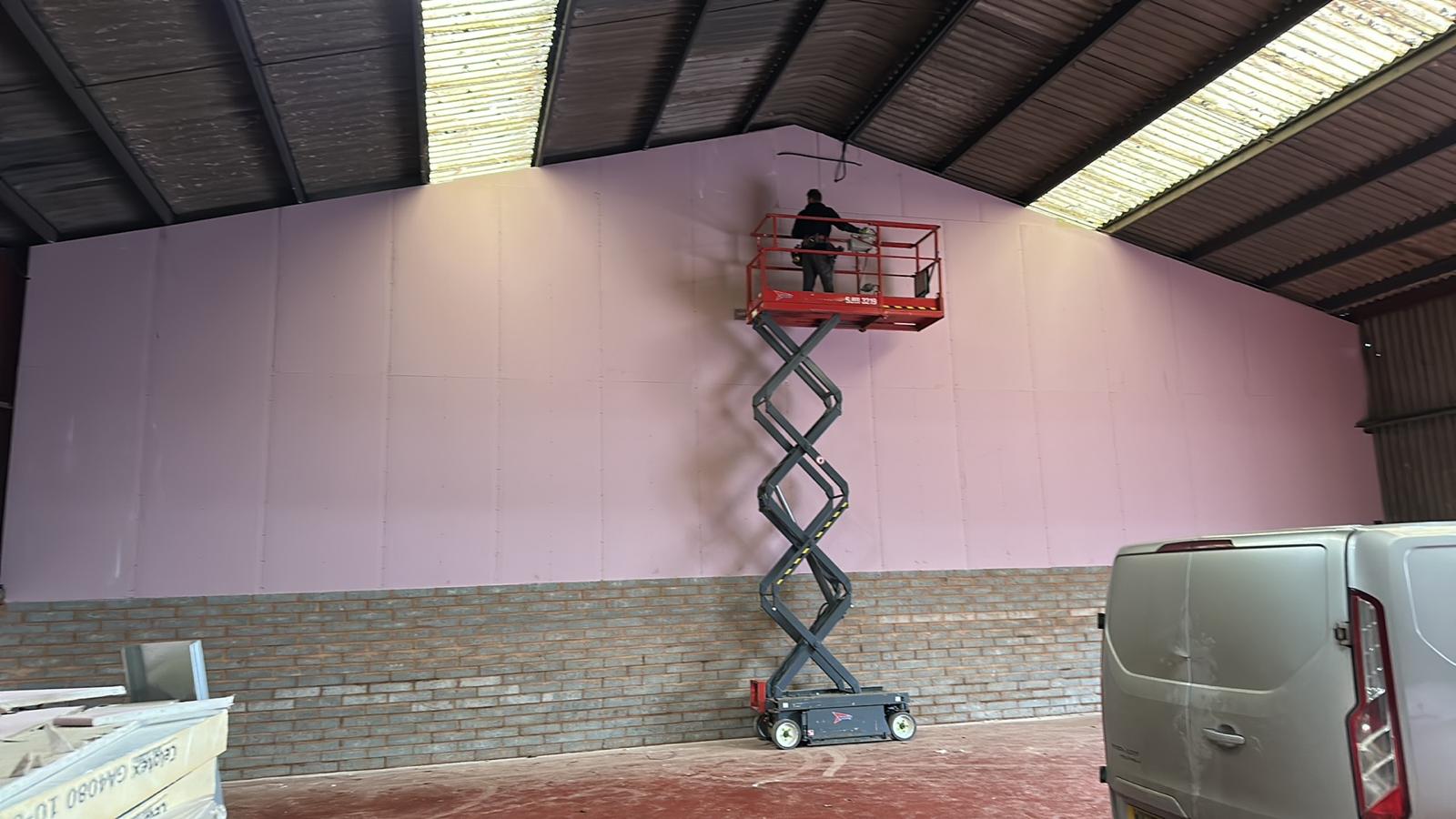Boarding the partition at height from the scissor lift, Wellington Industrial Units, JLG Construction Services