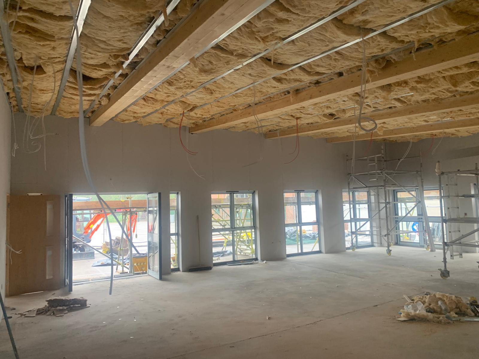 Insulation fitted overhead above the ceiling grid, Wimborne School, JLG Construction Services
